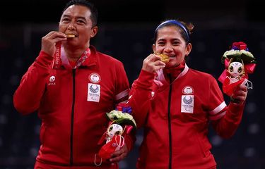 Atlet para-badminton Hary Susanto bersama Leani Ratri Oktila berpose dengan medali emas usai menundukkan atlet para-badminton Perancis Lucas Mazur dan Faustine Noel pada final ganda campuran SL3-SU5 Paralimpiade Tokyo 2020 di Yoyogi National Stadium, Tokyo, Jepang, Minggu (5/9/2021). Ganda campuran Indonesia tersebut meraih medali emas setelah memenangi pertandingan 23-21 dan 21-17.