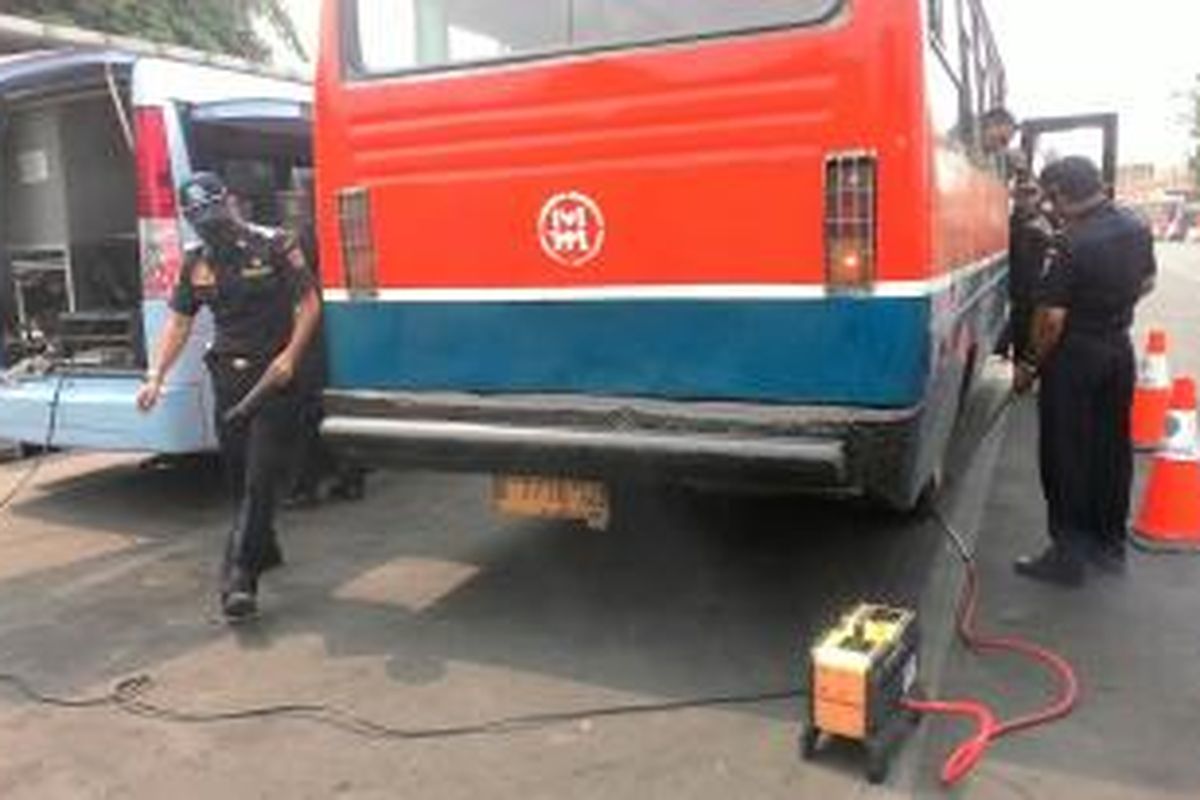 Petugas Pengujian Kendaraan Bermotor (PKB) tengah melakukan pengujian terhadap sebuah Metro Mini di Terminal Pulogadung, Jakarta Timur, Selasa (13/10/2015)