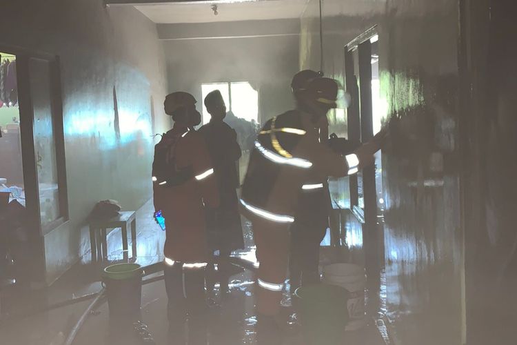 Petugas damkar dan penghuni pondok berupaya memadamkan api yang membakar asrama santriwati