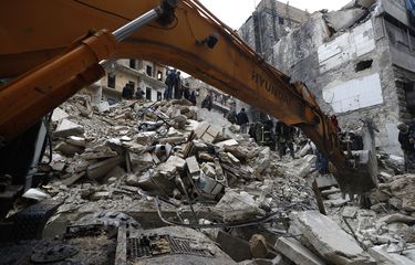 Para pekerja Pertahanan Sipil Suriah dan petugas keamanan menyisir puing-puing bangunan yang ambruk di Aleppo, Suriah, Senin (6/2/2023). Gempa Suriah terjadi bersamaan di Turkiye yang menewaskan lebih dari 5.000 orang.