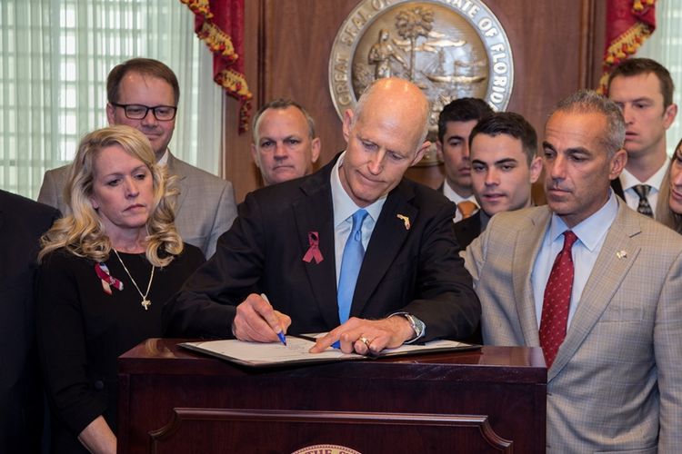 Gubernur Florida, Rick Scott, menandatangani peraturan terkait pembatasan senjata. Peraturan tersebut disahkan setelah munculnya kasus penembakan massal di SMA Marjory Stoneman Douglas (14/2/2018).