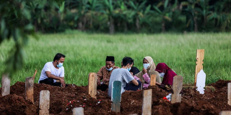 Warga membaca doa di dekat pusara keluarganya di Tempat Pemakaman Umum (TPU) Padurenan, Kota Bekasi, Jawa Barat, Rabu (18/6/2021). Satgas penanganan Covid-19 melaporkan kasus konfirmasi positif hingga Jumat (18/6/2021) bertambah 12.990 orang sehingga totalnya menjadi 1.963.266 kasus, sementara itu kasus meninggal akibat Covid-19 bertambah 290 jiwa sehingga totalnya telah menembus 54.043 jiwa.