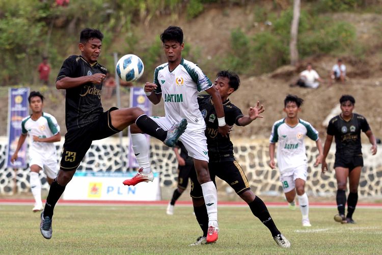 Pemain Jawa Timur (tengah) dijaga ketat pemain Jawa Tengah saat babak penyisihan grup B yang berakhir dengan skor 0-3 di Stadion Mahacandra Kota Jayapura, Jumat (1/10/2021) sore.