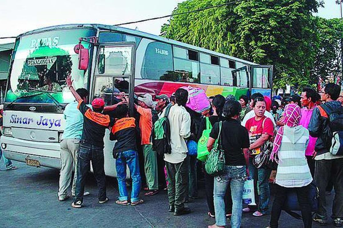 Sejumlah pemudik saling berebut naik bus Sinar Jaya di ruas jalan depan Terminal Pulogadung, Jakarta, Jumat (18/9). Penumpukan penumpang di terminal itu terjadi karena keterlambatan bus masuk ke Jakarta.