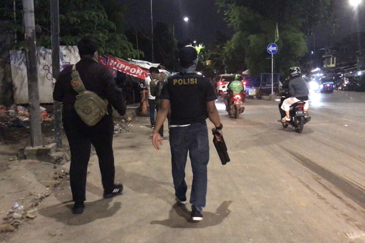 Polisi membawa senjata gas air mata untuk membubarkan warga yang terlibat tawuran di kawasan Manggarai, Tebet, Jakarta Selatan pada Senin (18/1/2021) malam.