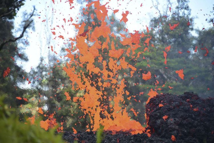 Semburan lahar yang muncul dari retakan terlihat di kawasan Leilani Estates di Hawaii, Jumat (4/5/2018). Letusan Gunung Kilauea diawali guncangan gempa berkekuatan magnitudo 6,9 yang memicu runtuhnya tebing pantai dan memuntahkan lahar di kawasan yang dekat dengan permukiman, memaksa ribuan orang untuk dievakuasi.