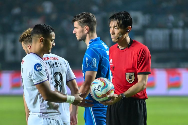 Wasit asal Jepang Futoshi Nakamura menyerahkan bola kepada pemain Persik Kediri Renan Silva setelah keputusan penalti diberikan dalam pertandingan pekan ke-22 Liga 1 2023-2024 antara Persib vs Persik Kediri, Minggu (10/12/2023) di Gelora Bandung Lautan Api (GBLA). 