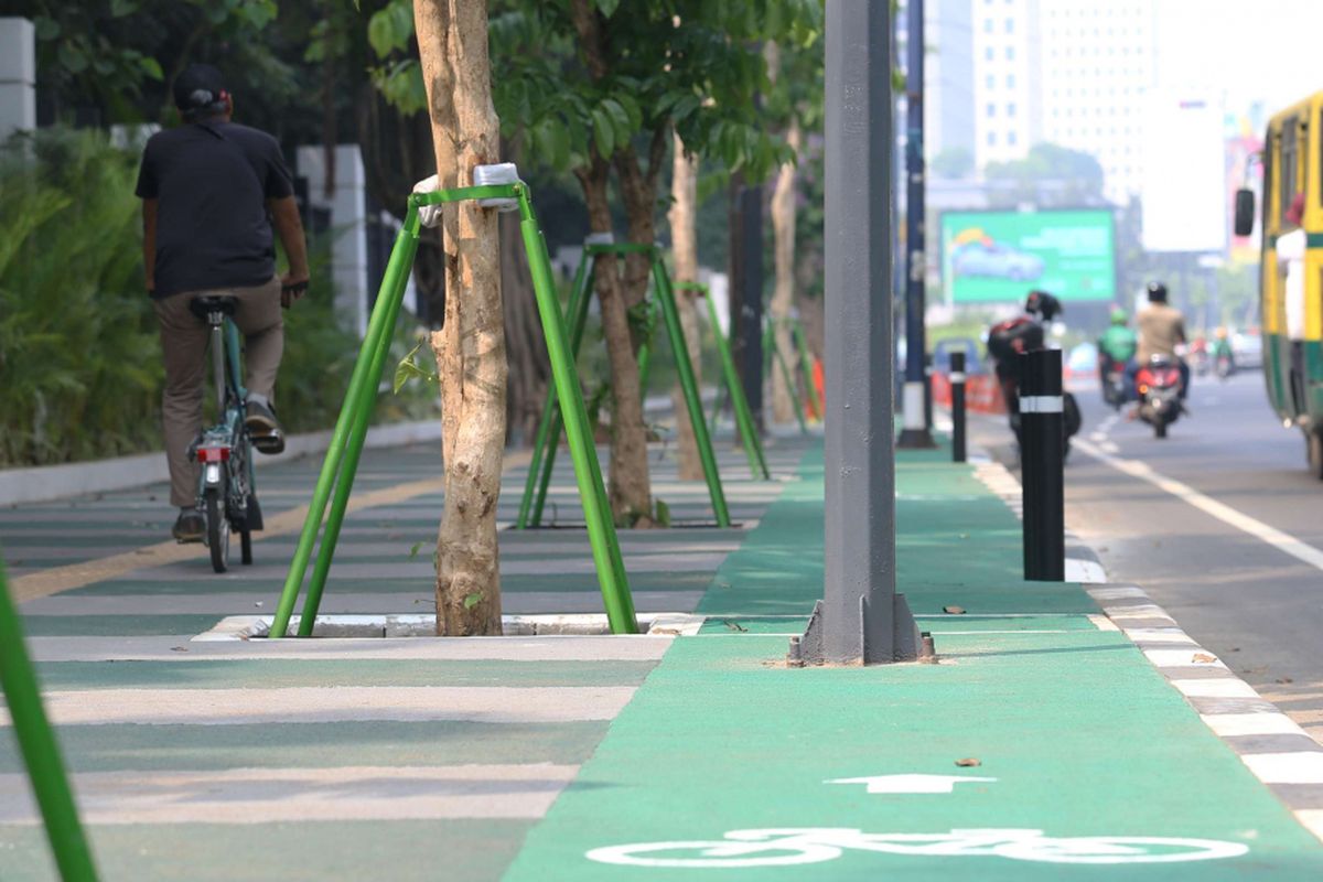 Seorang pesepeda melintas di luar jalur sepeda di Jalan Asia Afrika, Jakarta, Rabu (01/08/2018). Jalur sepeda di sepanjang jalan ini terhalang beberapa tiang lampu penerangan jalan umum (PJU), tiang lampu lalu lintas, hingga tiang rambu penunjuk jalan.