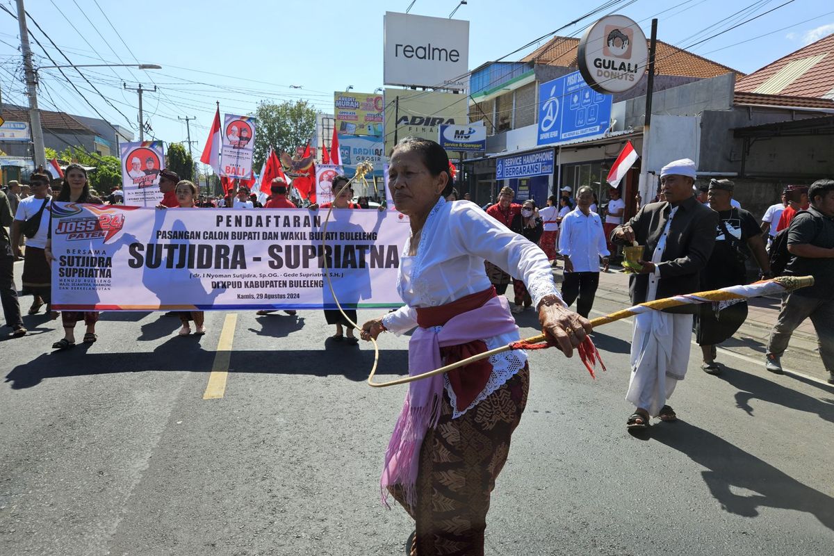 Parade seni budaya mengiringi pendaftaran bakal pasangan calon bupati dan wakil bupati dalam Pilkada Buleleng 2024, Nyoman Sutjidra dan Gede Supriatna. Pasangan ini mendaftar ke KPU Kabupaten Buleleng, Bali, Kamis (29/8/2024) pagi. 