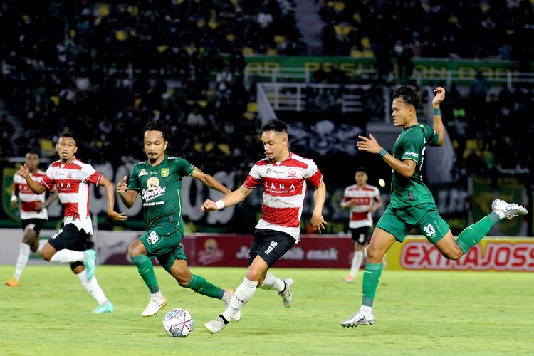 Pemain Madura United Lulinha dijaga ketat pemain Persebaya Surabaya saat pertandingan pekan 4 Liga 1 2022-2023 yang berakhir dengan skor 2-2 di Stadion Gelora Bung Tomo Surabaya, Minggu (14/8/2022) sore.