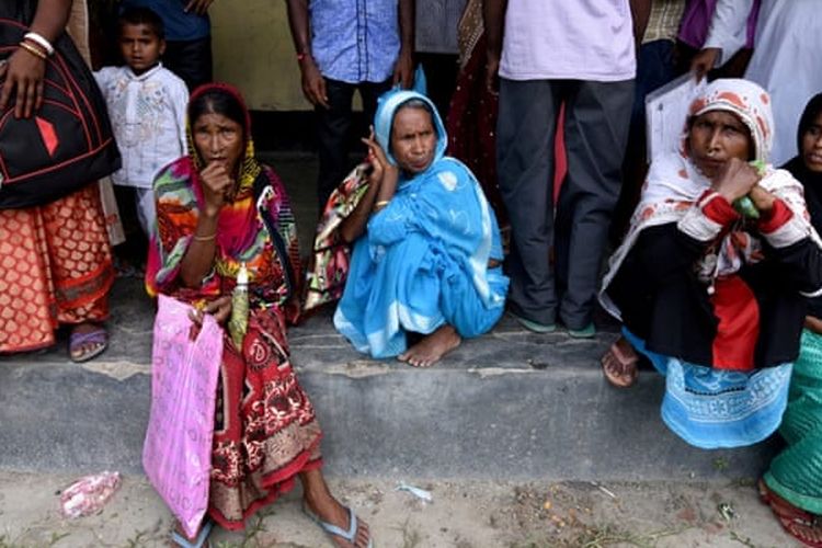 Beberapa warga menunggu untuk melihat rancangan peraturan pencatatan sipil di Negara Bagian Assam, India. Rancangan itu menjadi kontroversial karena menghilangkan kewarganegaraan empat juta penduduknya.