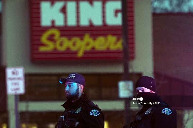 Aparat kepolisian berjaga di luar tempat parkir toko King Soopers di Boulder, Colorado pada 22 Maret 2021, setelah insiden penembakan massal.