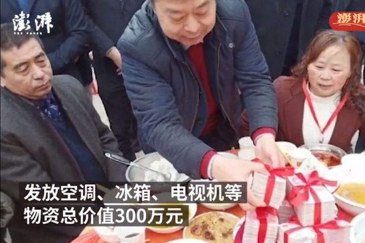 Miliarder asal China, Zheng Daqing, membagikan uang tunai yang diikat dengan pita merah kepada penduduk desa di kampung halamannya di Dingziqiao, provinsi Sichuan. (SCMP)