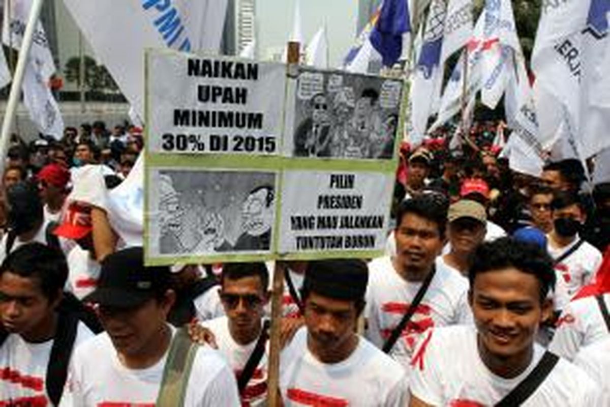 Ribuan buruh dari berbagai organisasi berunjuk rasa memperingati Hari Buruh Internasional, melintasi Jalan MH Thamrin, Jakarta Pusat, Kamis (1/5/2014). Hari Buruh Internasional ditetapkan sebagai hari libur nasional untuk kali pertama di tahun ini, diperingati dengan berunjuk rasa menuntut upah layak, penghapusan outsourcing, dan penolakan terhadap undang-undang Badan Penyelenggara Jaminan Nasional. TRIBUNNEWS/HERUDIN