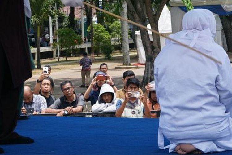 Salah seorang dari enam terpidana kasus ikhtilat (bercumbu) dicambuk di Taman Bustanus Salatin, yang berjarak sekitar satu kilometer dari Masjid Raya Baiturrahman, Banda Aceh, Kamis (19/9/2019). 