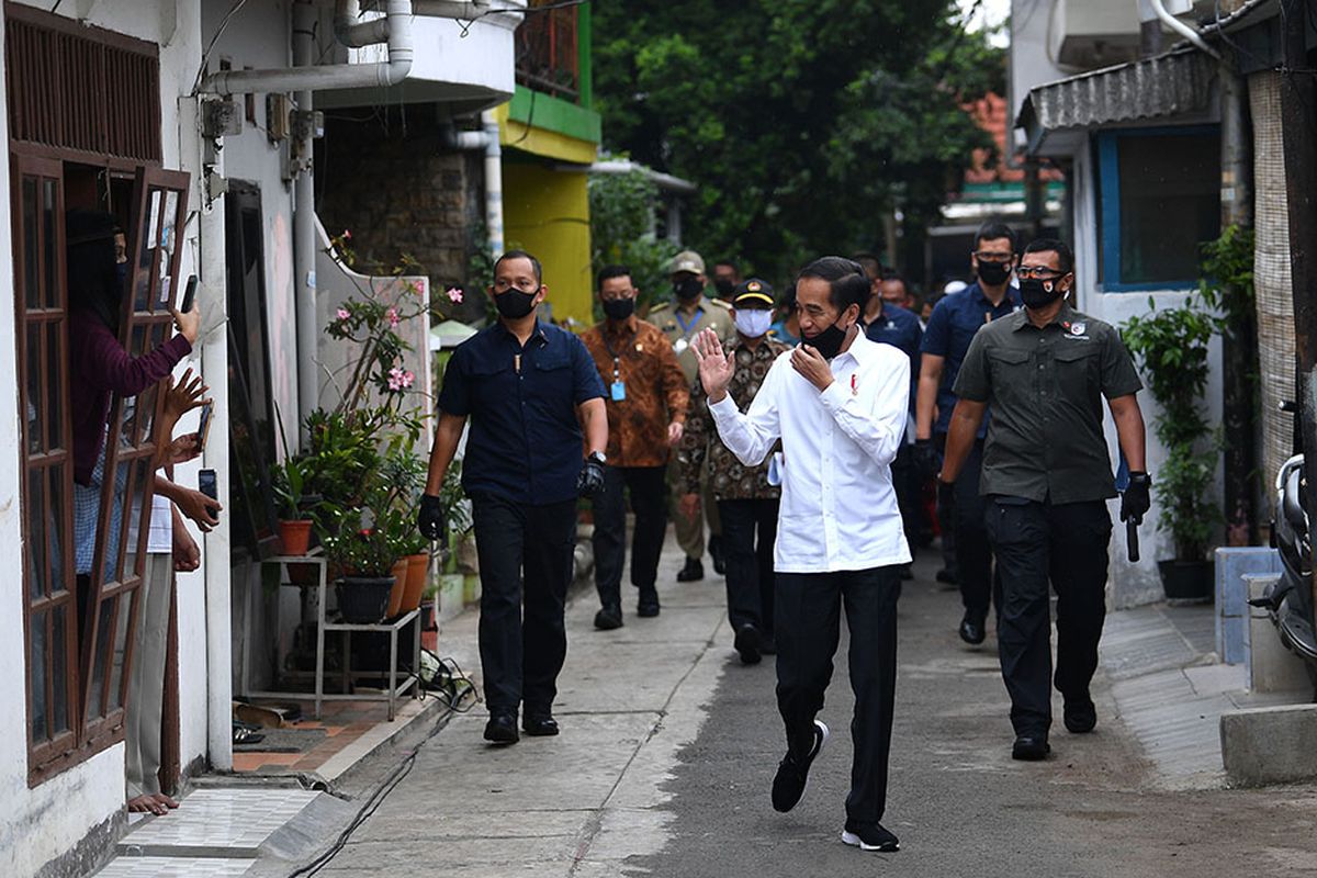 Presiden Joko Widodo (tengah) menyapa warga saat meninjau proses distribusi sembako tahap ketiga bagi masyarakat kurang mampu dan terdampak COVID-19 di kawasan Johar Baru, Jakarta Pusat, Senin (18/5/2020). Dalam blusukan ini, Presiden Jokowi ingin mengecek langsung penyaluran sembako pada masyarakat setempat.