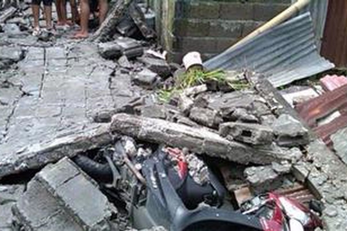 Sebuah sepeda motor tertimbun reruntuhan tembok setinggi 3,5 yang roboh disapu angin kencang di Gang Kenari 1, Desa Dangin Puri Kaja, Jalan Nangka, Denpasar, Rabu (09/01/2012).