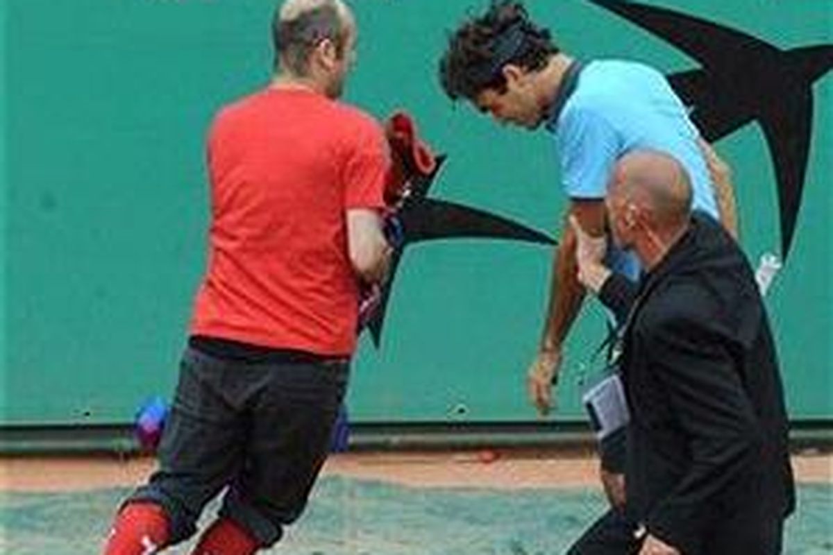 Seorang penonton mencoba merebut ikat kepala yang dikenakan Roger Federer (tengah) di final Perancis Terbuka, Minggu (7/6).