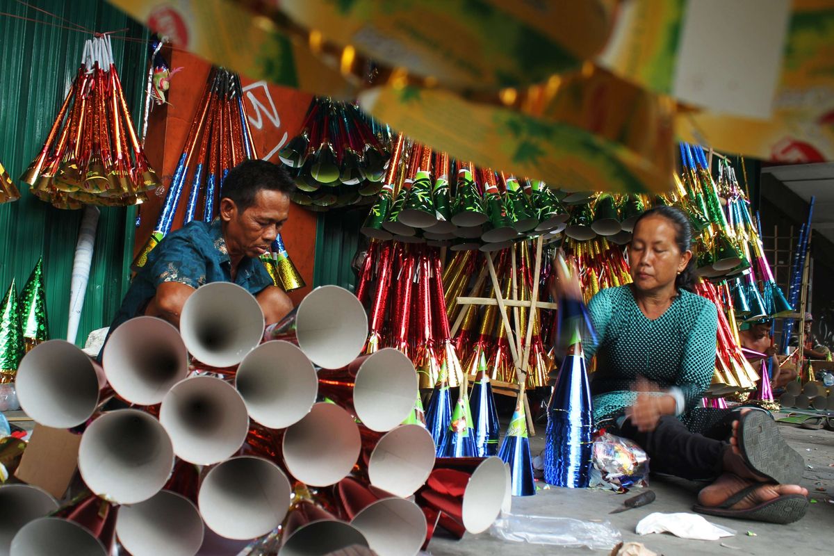 Pengrajin menyelesaikan pembuatan terompet yang terbuat dari karton dipajang di depan pertokoan wilayah Glodok, Jakarta Barat, Minggu (29/12/2019). Menjelang pergantian tahun pengrajin terompet tingkatkan produksi.