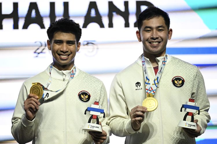 Pebulu tangkis ganda putra Indonesia M Reza Pahlevi Isfahani (kiri) dan Sabar Karyaman Gutama (kanan) berpose dengan medali usai upacara penghargaan pemenang (UPP)  final ganda putra bulu tangkis SEA Games 2025 di Gymnasium Thammasat University, Pathum Thani, Bangkok, Thailand, Minggu (14/12/2025). M Reza Pahlevi Isfahani dan Sabar Karyaman Gutama meraih medali emas setelah berhasil mengalahkan pasangan Malaysia Aaron Chia dan Soh Wooi Yik dengan dua gim langsung 21-14, 21-17. ANTARA FOTO/Nova Wahyudi/agr 
