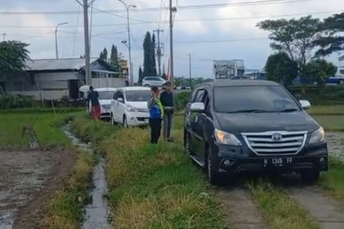 Tiga mobil yang masuk jalan persawahan diminta mundur hingga jalan utama agar tak tersesat.