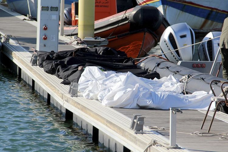 Mayat migran yang ditutupi difoto di pelabuhan Sfax, Tunisia tengah, Kamis, 24 Desember 2020. Sekitar 20 migran Afrika ditemukan tewas Kamis setelah kapal penyelundup mereka tenggelam di Laut Mediterania ketika mencoba mencapai Eropa, kata pihak berwenang Tunisia. Empat wanita yang tewas diketahui sedang mengandung (hamil).