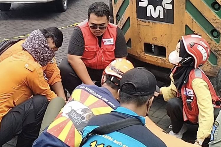 Proses evakuasi jenazah pria paruh baya di Surabaya yang tewas terlindas alat berat, Selasa (30/1/2024).