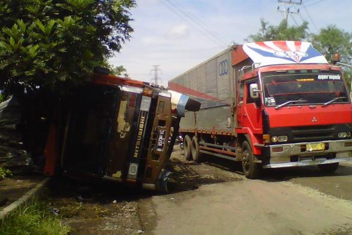 Sebuah truk terguling di Jalan Pembangunan, Kecamatan Cibeureum, Sukabumi, Jawa Barat, Kamis (28/4/2016). 