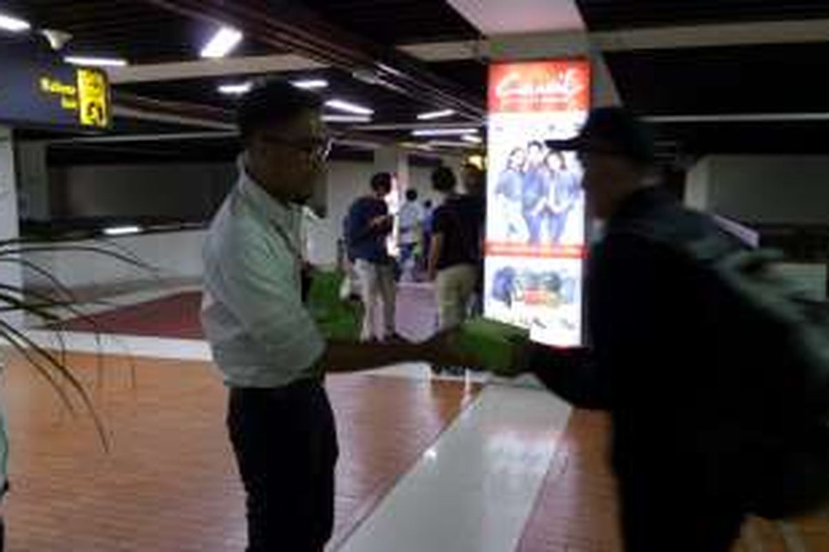 Sejumlah penumpang yang baru mendarat, dibagikan takjil gratis di Terminal 1 Bandara Soekarno-Hatta, Senin (6/6/2016) petang. Pada bulan Ramadhan kali ini, manajemen Bandara Soekarno-Hatta membagikan 4.300 boks takjil setiap harinya yang berisi roti, kurma, dan air mineral. 
