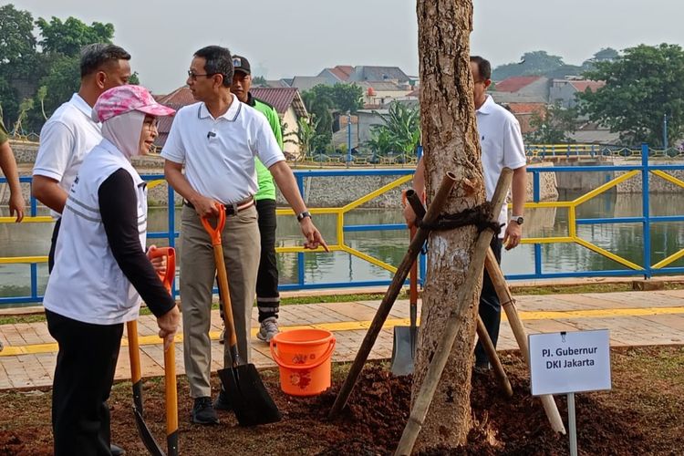 Pj Gubernur DKI Jakarta Heru Budi Hartono bersama Ketua Kadin DKI Jakarta Diana Dewi menanam pohon di Embung Jagakarsa, Jumat (16/2/2024).