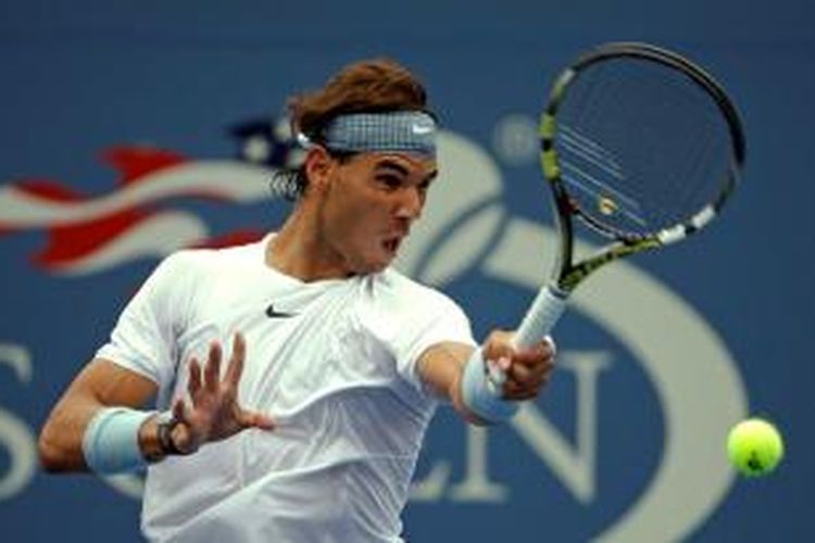 Petenis Spanyol, Rafael Nadal, mengembalikan bola ke arah Ryan Harrison dari Amerika Serikat, pada babak pertama US Open di New York, Senin (26/8/2013). Nadal menang 6-4, 6-2, 6-2.