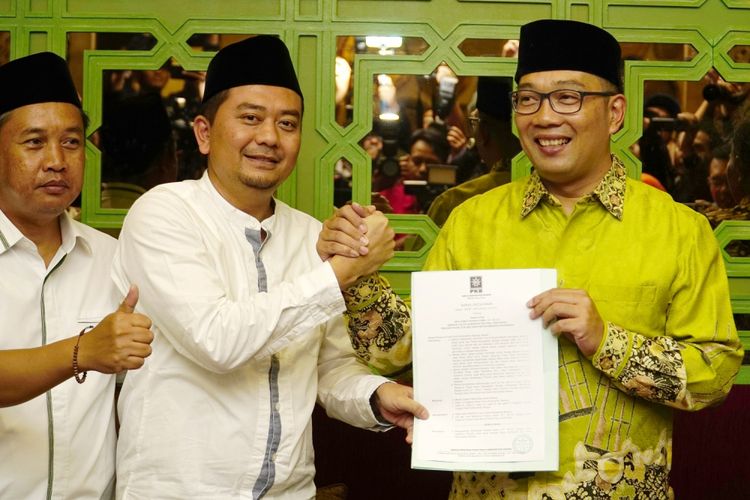 Ketua DPW PKB Jawa Barat Syaiful Huda (tengah) berjabat tangan dengan Wali Kota Bandung Ridwan Kamil (kanan) memberikan memberikan Surat Keputusan Dukungan PKB kepada Ridwan Kamil sebagai Calon Gubernur Jabar, Bandung, Jawa Barat, Senin (11/9). Setelah bergabungnya PKB yang memiliki tujuh kursi di DPRD Jabar, Ridwan Kamil kini memiliki 12 kursi dari partai sebelumnya Nasdem yang memiliki lima kursi, sehingga masih dibutuhkan dukungan sebanyak delapan kursi lagi, agar dirinya dapat diusung menjadi Calon Gubernur Jawa Barat 2018-2023, sesuai dengan syarat yang ditetapkan KPU dengan dukungan minimal 20 persen kursi di DPRD Jabar. ANTARA FOTO/Agus Bebeng/aww/17.