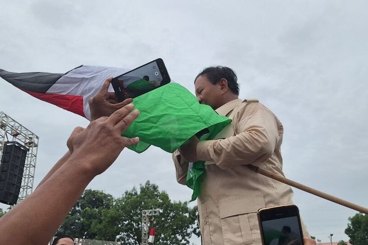 Prabowo mencium bendera Palestina saat berkampanye di Batam, Kepulauan Riau, Sabtu (13/1/2024).
