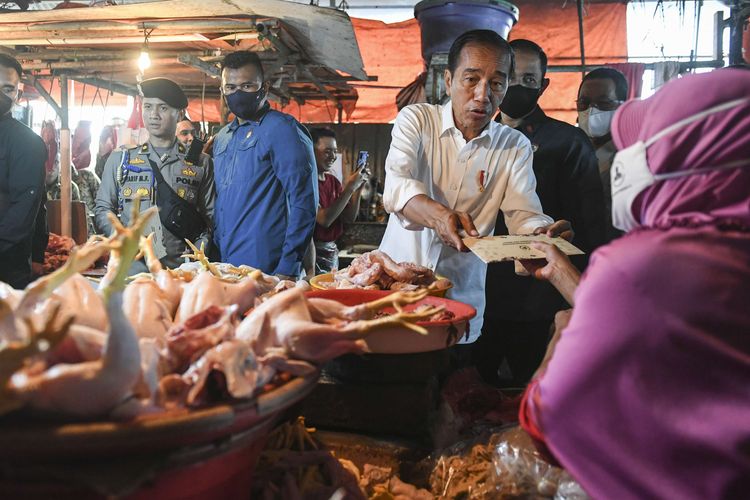 Presiden Joko Widodo menyerahkan bantuan kepada pedagang saat mengunjungi Pasar Minggu, Jakarta, Kamis (13/4/2023). Kunjungan Presiden ke pasar tersebut untuk memantau harga kebutuhan pokok jelang Lebaran dan membagikan paket bantuan sosial kepada pedagang dan masyarakat.