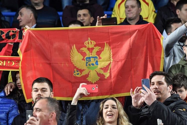 Suporter Montenegro mengibarkan bendera pada laga versus Inggris dalam babak kualifikasi Euro 2020 di Podgorica City, 25 Maret 2019. 