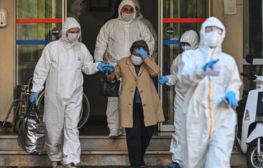 Petugas medis mengenakan pakaian pelindung (hazmat) mengawal perempuan yang diduga terinfeksi virus corona di Istanbul, Turki, pada 12 April 2020.