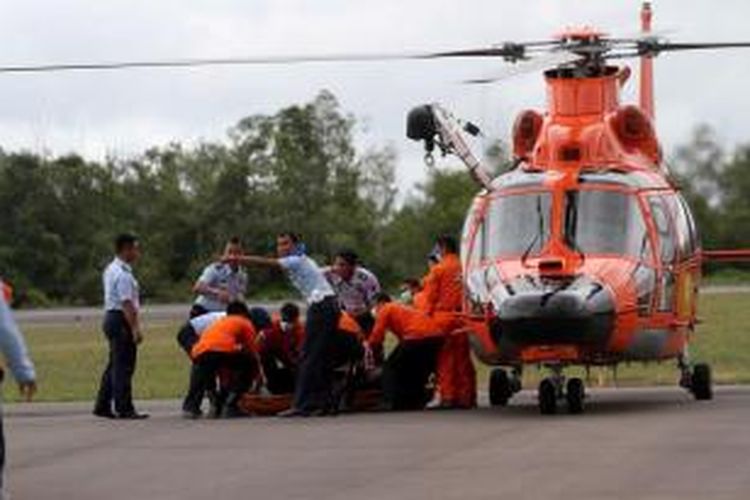 Petugas Basarnas membawa jenazah dari helikopter menuju ambulans di Posko Utama Pecarian Pesawat AirAsia QZ8501, Lanud Iskandar, Pangkalan Bun, Kalteng, Rabu (31/12/2014). Dua dari tujuh jenazah yang telah ditemukan dibawa ke posko untuk kemudian diidentifikasi di RSUD Sultan Imanudin.