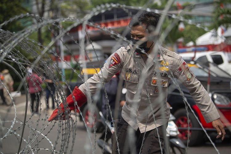 Polisi menata barikade kawat berduri dalam pengamanan sidang putusan banding Rizieq Shihab terkait perkara tes swab RS Ummi Bogor di Pengadilan Tinggi DKI Jakarta, Jakarta, Senin (30/8/2021). Majelis Pengadilan Tinggi DKI Jakarta menolak permohonan banding Rizieq Shihab dkk dan tetap dengan vonis empat tahun penjara.