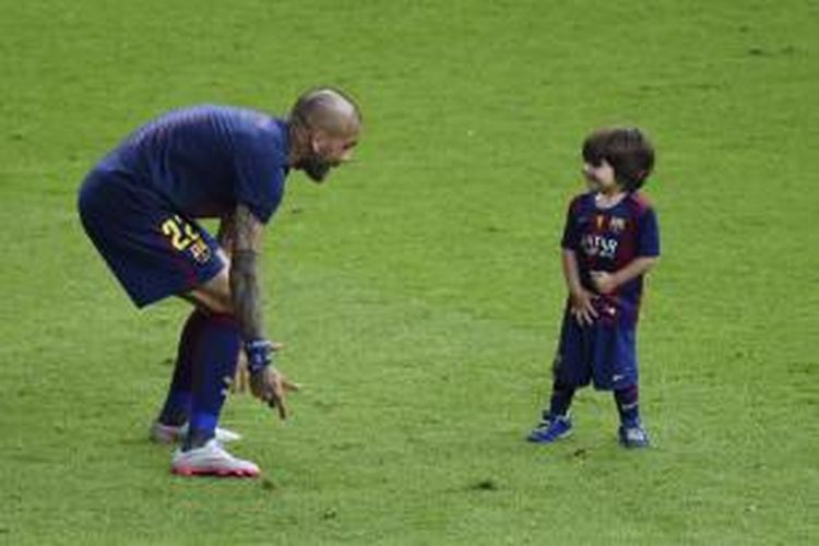 Daniel Alves bicara kepada anak Gerrard Pique, Milan Pique Mubarak, ketika perayaan juara Liga Champions di Olympiastadion, Berlin, Sabtu waktu setempat atau Minggu (7/6/2015) dini hari WIB. 