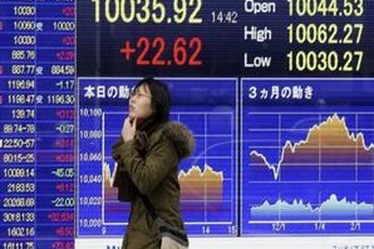 A woman walks past the electronic stock board of a securities firm in Tokyo, Tuesday, Feb. 16, 2010. Asian stocks were modestly higher Tuesday in holiday-thinned trade as investors awaited another top level European finance meeting on Greeces debt crisis. Japans Nikkei 225 stock average was up 38.07 points, or 0.4 percent, at 10,051.37.