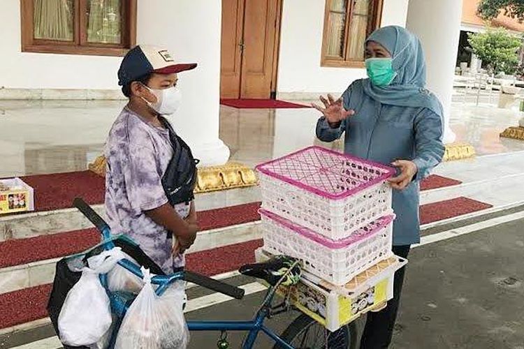 Gubernur Jawa Timur, Khofifah Indar Parawansa saat berbincang dengan bocah penjual donat keliling, Rangga Supriyadi di Gedung Grahadi, Rabu (31/3/2021). 
