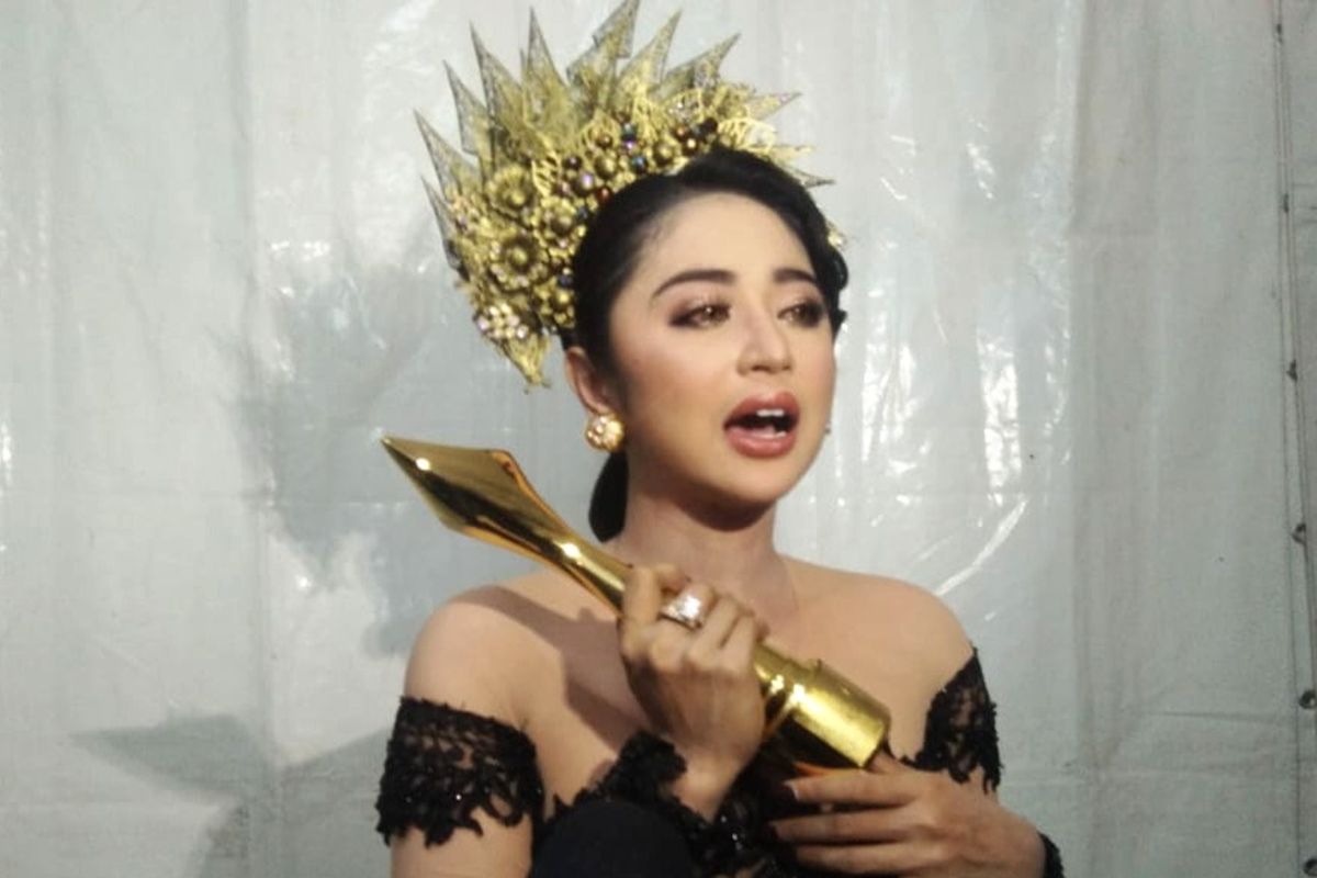 Dewi Persik memegang piala ADI 2019 kategori Penyanyi Dangdut Paling Gaya di Lapangan Galuh Mas, Karawang, Minggu (18/11/2019).