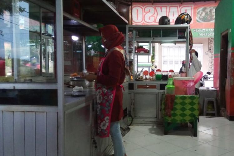 Seorang penjual bakso dan mi ayam di Jl. Jend. Gatot Subroto, Desa Ngijo, Tasikmadu, Karanganyar, Jawa Tengah (Jateng), Ny. Hidayat, 31, mengenakan masker saat berjualan, Jumat (6/11/2020) pukul 13.20 WIB.