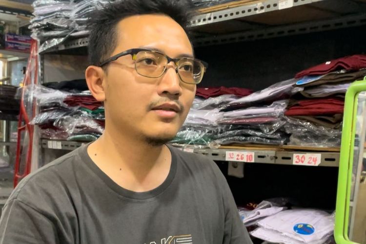 Rizal (32), pedagang seragam sekolah di Pasar Koja Baru saat ditemui Kompas.com, Selasa (24/10/2023).