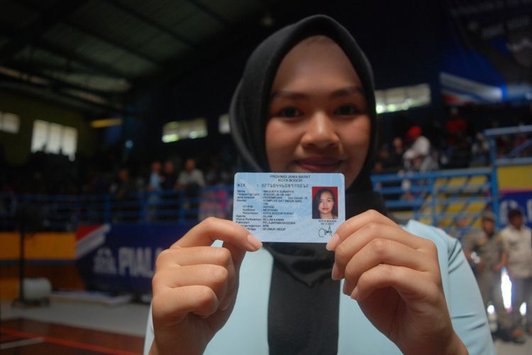 Seorang warga Kota Bogor menunjukkan e-KTP yang diterimanya dalam acara pembagian KTP elektronik secara serentak di Gedung Hall A GOR Pajajaran, Minggu (5/11/2017)