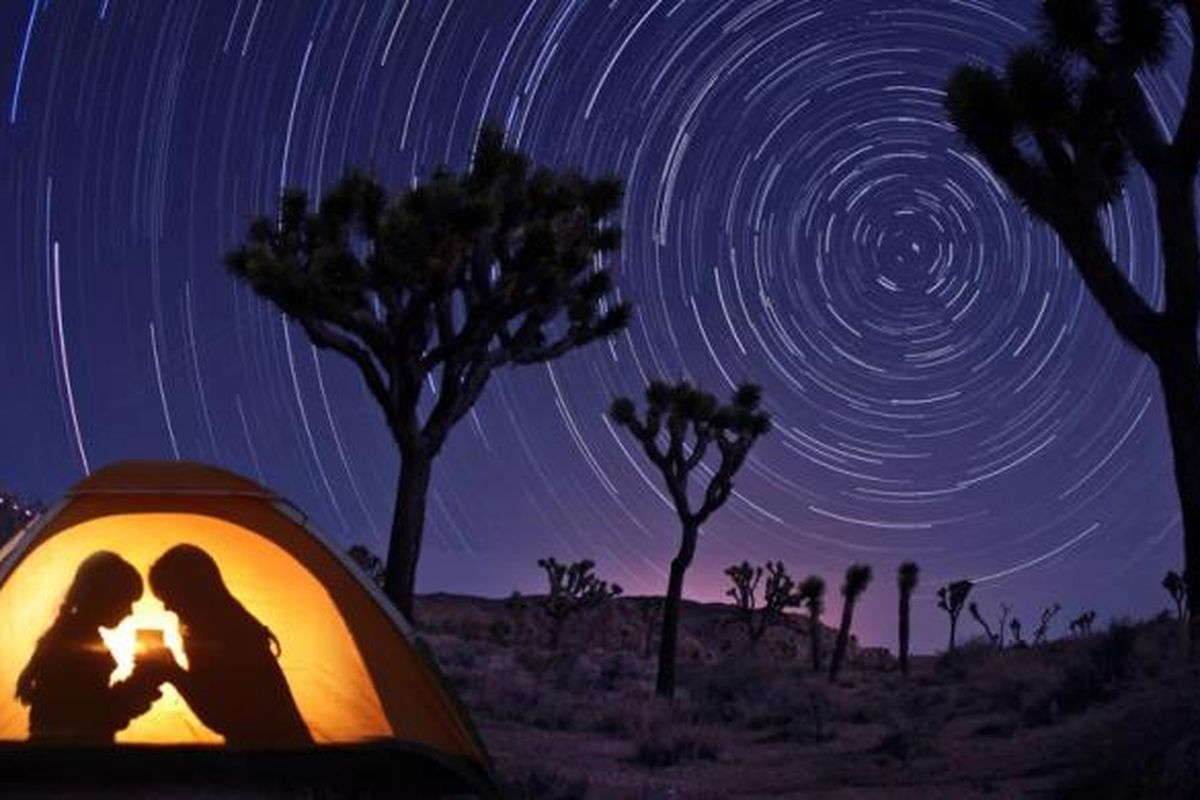 Anak-anak menikmati malam di dalam tenda di bawah cahaya alami bintang-bintang.