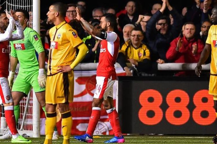 Theo Walcott merayakan gol Arsenal ke gawang Sutton pada partai babak kelima Piala FA di Stadion Borough Sports Ground, Senin (20/2/2017).