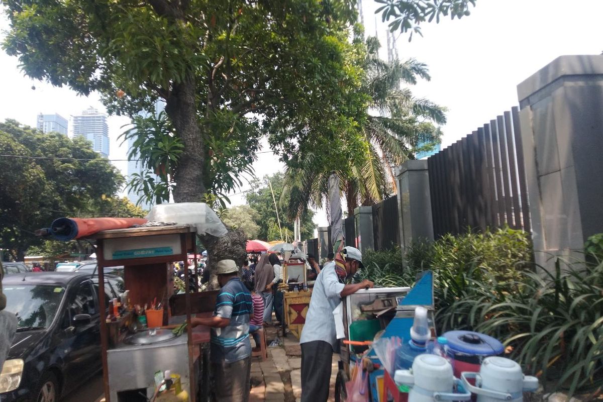 Sejumlah pedagang di depan TPU Karet Bivak, Tanah Abang, Jakarta Pusat, laris manis dibeli oleh peziarah usai nyekar ke makam sanak keluarga pada Minggu (27/3/2022).