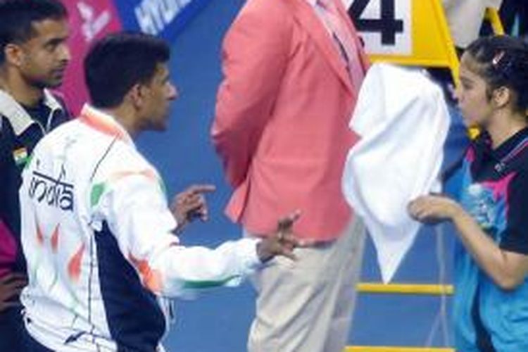 Pebulu tangkis India, Saina Nehwal (kanan), berbicara dengan pelatih Pullela Gopichand (kiri), dan Vimal Kumar saat bertanding di Asian Games.