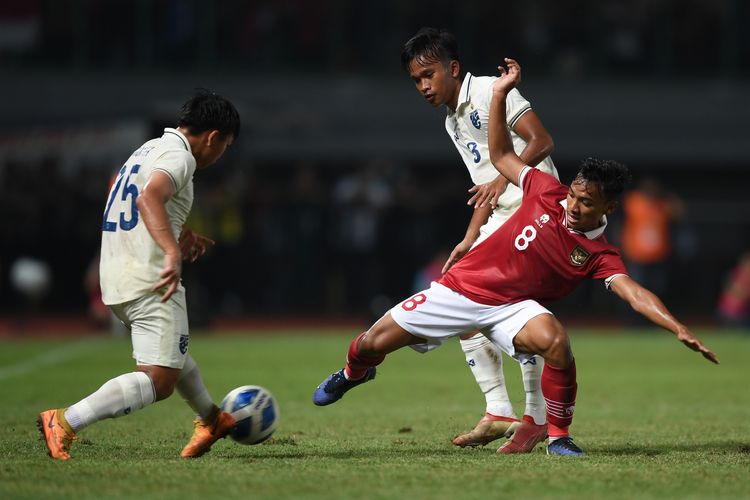 Pesepak bola Indonesia U19 Arkhan Fikri (tengah) berebut bola dengan pesepak bola Thailand U19 Phon-Ek Maneekom (kiri) dan Thawatchai Inprakhon (kanan)  dalam laga penyisihan grup Piala AFF U19 di Stadion Patriot Candrabhaga, Bekasi, Jawa Barat, Rabu (6/7/2022). ANTARA FOTO/Akbar Nugroho Gumay/foc.